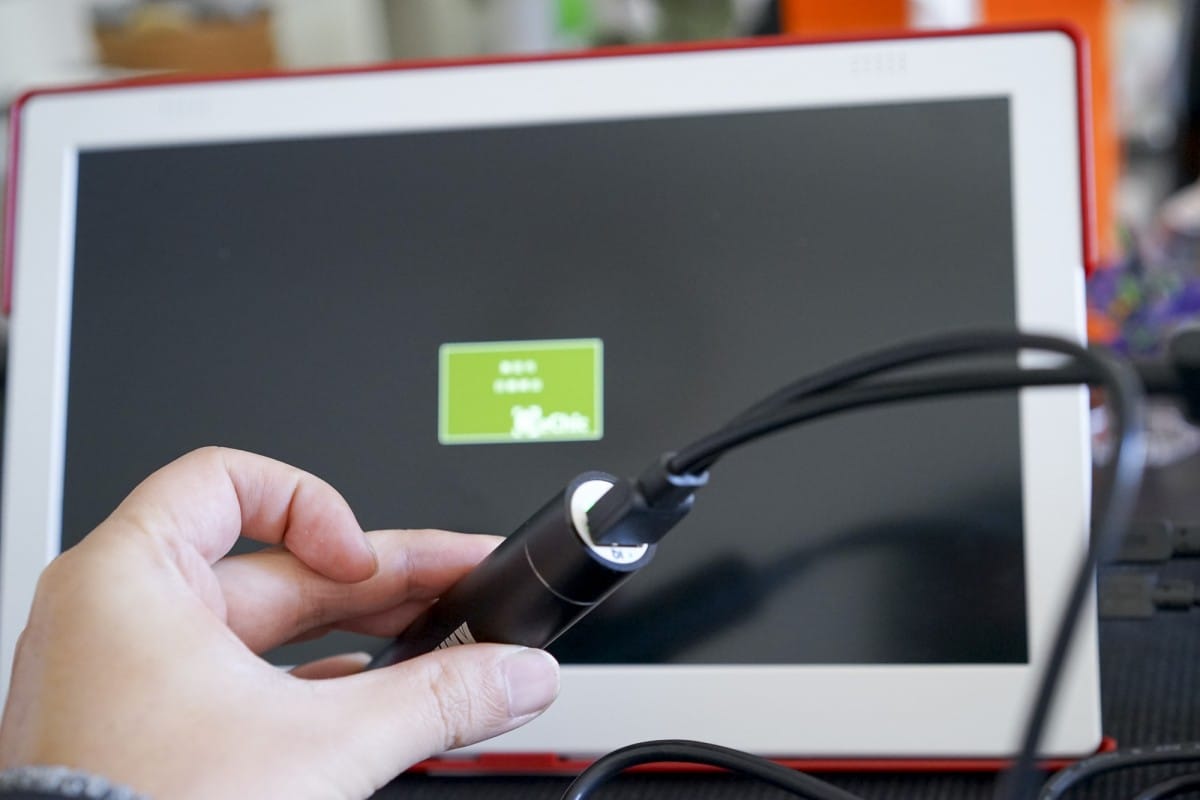 A hand holding a laptop