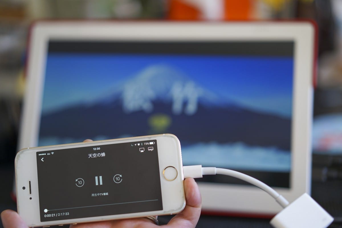 A hand holding a laptop computer