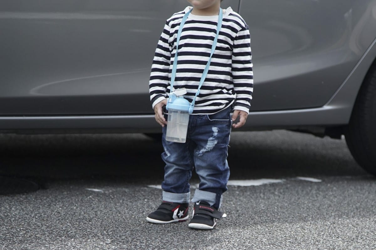 DSC09916 A young boy standing in front of a car
