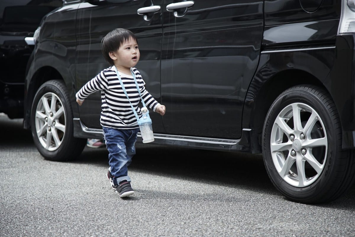 DSC09920 A young boy standing in front of a car