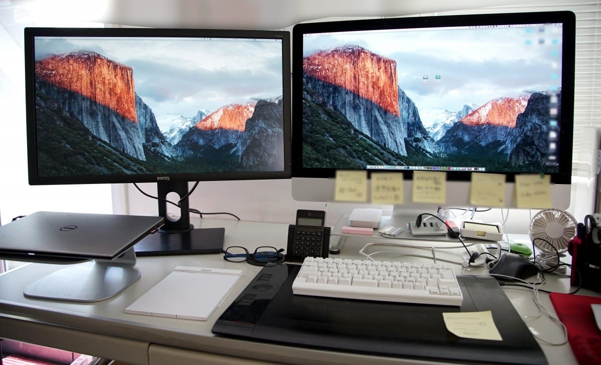 A desk with a monitor keyboard and mouse on a table