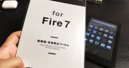 A hand holding up a laptop computer